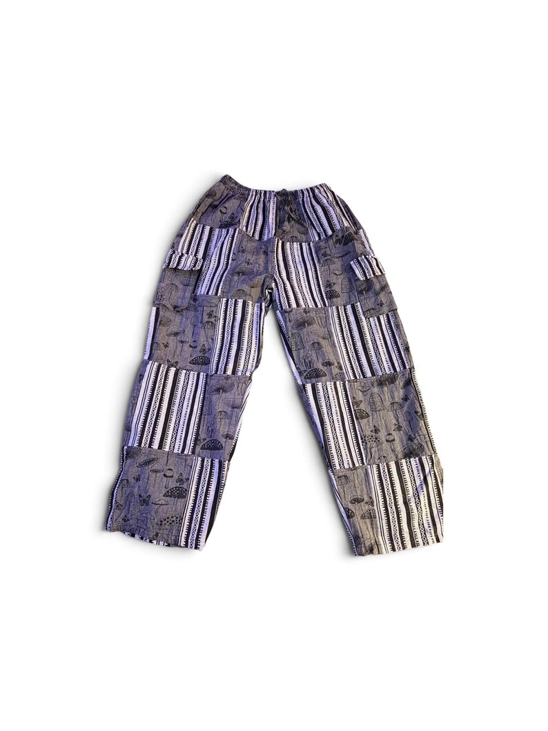 May include: Loose-fitting pants featuring a patchwork design of alternating vertical stripes and panels with a dark gray mushroom and butterfly print. The garment has an elasticized waistband and two side cargo pockets on the upper thighs.