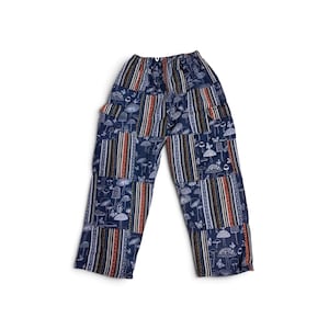 May include: Navy blue trousers featuring a patchwork design with alternating panels. One panel type displays a white line-art pattern of various mushrooms and butterflies, while the other features vertical stripes in orange, white, and black.