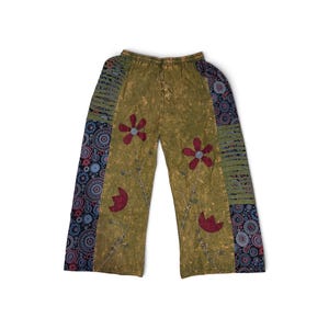 May include: Olive green wide-leg pants featuring a mottled texture, an elastic drawstring waistband, and dark blue side panels with circular patterns. The front displays embroidered red flower motifs with thin stems and light blue accents.