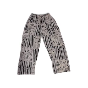 May include: A pair of light gray pants featuring a patchwork design with alternating panels of black and white vertical stripes and a repeating black ink-style print of various mushrooms, small butterflies, and botanical elements throughout.