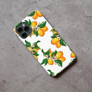 Könnte beinhalten: Eine weiße Handyhülle mit einem sich wiederholenden Muster aus gelben Zitronen, grünen Blättern und weißen Blüten. Die Hülle hat eine glänzende Oberfläche und einen Kameraausschnitt.