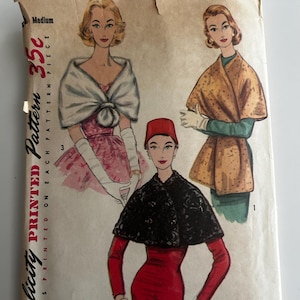 May include: Vintage Simplicity printed pattern 1755. The pattern features illustrations of women wearing capes and shawls. The price is 35 cents. The cover is beige with red and black text and illustrations.