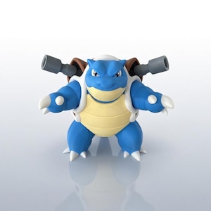 May include: A blue and yellow Blastoise figurine with two gray cannons on its back. The figure has white accents on its limbs and shell. The figurine is standing on a reflective surface.