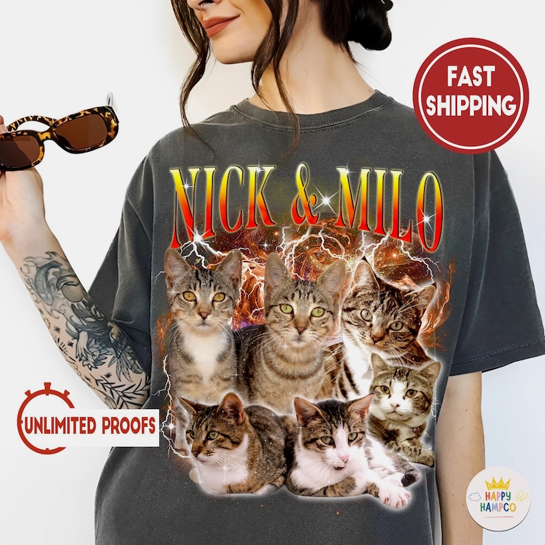 May include: Dark gray t-shirt featuring a graphic of six cats with the text "NICK & MILO" in a red and yellow font. The cats are in various poses, with a background of lightning and stars.