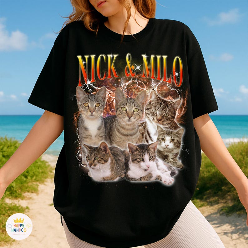 May include: Black t-shirt featuring a graphic of six cats with a lightning and fire effect. The text "NICK & MILO" is displayed in a fiery font above the cats. The shirt is a crew neck and has short sleeves.