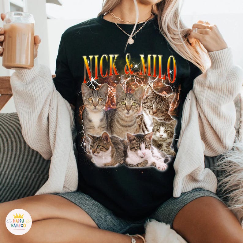 May include: Black long-sleeve shirt featuring a graphic of six cats with the text "NICK & MILO" in a stylized font. The cats are various shades of brown, gray, and white. The shirt has a crew neck.