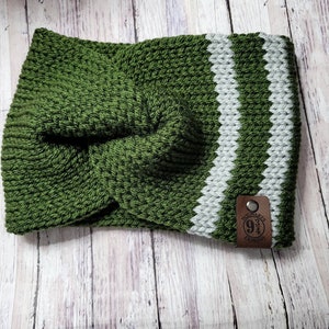 Pode incluir: Uma faixa de cabeça de malha verde e cinza com um design torcido. A faixa de cabeça apresenta duas listras cinza verticais e uma etiqueta de couro marrom com o texto "Hogwarts 9 3/4 Express".
