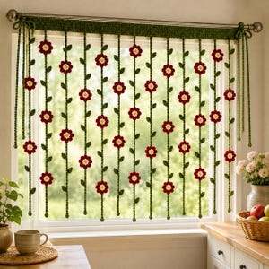 May include: A crochet window valance featuring a horizontal green band with hanging vertical strands. Each strand is decorated with small, dark red flowers with white centers and green leaves. The valance is suspended from a metal curtain rod.