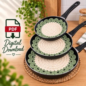 May include: Three round, crocheted pan protectors in cream and sage green, each featuring a scalloped edge. These circular mats are stacked inside three black frying pans of varying sizes. The image includes the text PDF Digital Download.