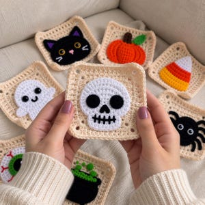 Może przedstawiać: Kolekcja kwadratowych naszywek szydełkowych z aplikacjami o tematyce Halloween, w tym biała czaszka, czarny kot, pomarańczowa dynia, cukierek kukurydziany, biały duch, czarny pająk, zielona gałka oczna i czarny kociołek.
