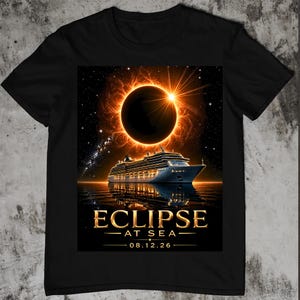 May include: A black t-shirt featuring a graphic of a cruise ship on the water under a solar eclipse. The text reads ECLIPSE AT SEA and 08.12.26 in gold lettering. The design includes a starry night sky and the glowing corona of the sun.