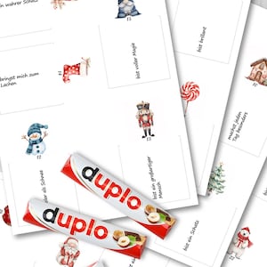 Puede incluir: Una colecci&oacute;n de tarjetas blancas con ilustraciones de acuarela de tem&aacute;tica navide&ntilde;a, incluyendo un mu&ntilde;eco de nieve, un hombre de jengibre y Pap&aacute; Noel. Tambi&eacute;n se ven dos barras de chocolate Duplo, con envoltorios rojos y blancos.