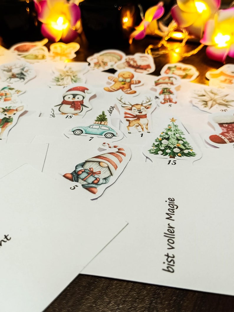 May include: A collection of Christmas-themed stickers featuring festive illustrations. Designs include a penguin, reindeer, Christmas tree, gingerbread man, and a gnome. The stickers are on a white surface, with some text visible.