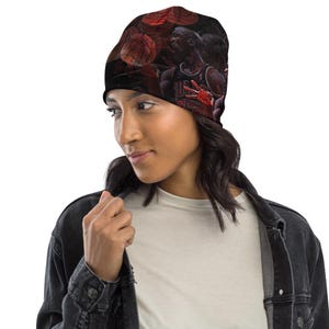 Puede incluir: Gorro negro con un dise&ntilde;o de jugador de baloncesto con detalles en rojo y negro. El gorro presenta un patr&oacute;n repetido de balones de baloncesto y un jugador con una camiseta. El gorro lo lleva una persona.