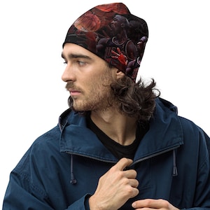 Puede incluir: Gorro negro con un dise&ntilde;o de baloncesto, con un retrato de un jugador de baloncesto. El gorro tiene un fondo oscuro con balones de baloncesto y un jugador con uniforme rojo y negro. El gorro lo lleva una persona con una chaqueta azul.