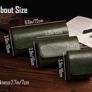 Pu&ograve; includere: Custodie per orologi in pelle verde di varie dimensioni sono esposte su una superficie di legno. La custodia pi&ugrave; grande misura 22 cm di lunghezza, 10 cm di altezza e ha uno spessore di 7 cm. Il testo "About Size" &egrave; incluso.