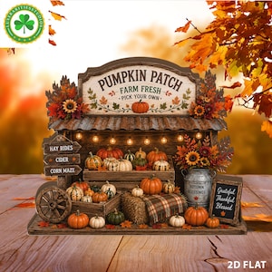 Könnte beinhalten: Ein dekorativer Kürbisstand mit einem Schild mit der Aufschrift PUMPKIN PATCH FARM FRESH PICK YOUR OWN. Das Display enthält Holzkisten mit orangefarbenen und weißen Kürbissen, einen Metalleimer mit der Aufschrift AUTUMN BLESSINGS und eine Tafel.