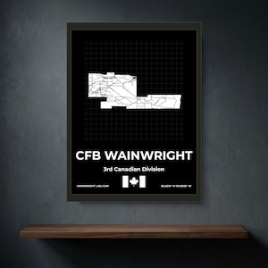 May include: A framed black and white map print of CFB Wainwright, 3rd Canadian Division. The design features a white grid map on a black background, the text CFB WAINWRIGHT, 3rd Canadian Division, a Canadian flag icon, and coordinates 52.8216 N 110.8832 W.