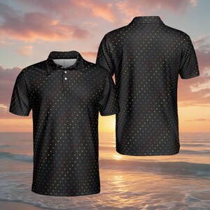 Könnte beinhalten: Ein schwarzes kurzärmeliges Poloshirt mit einem durchgehenden Muster aus kleinen, bunten Herzsymbolen. Das Shirt verfügt über einen klassischen Kragen, eine Knopfleiste mit zwei sichtbaren weißen Knöpfen und einen geraden Saum, von vorne und hinten.