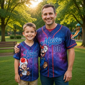 May include: Two people wearing matching baseball jerseys with a galaxy design. One jersey says "Mario" and the other says "Toad", both with the number "00". The jerseys feature cartoon characters and are set against a park background.