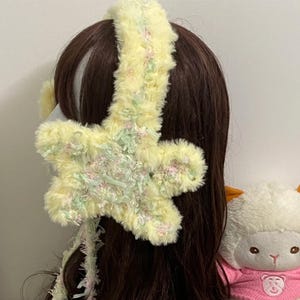 Calentador de orejas de estrella amarilla: Patrón de invierno tejido a crochet hecho a mano.