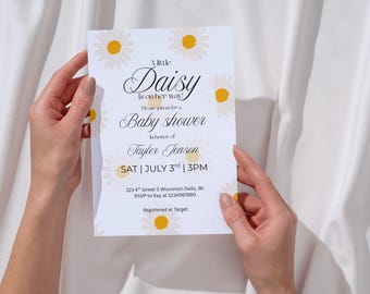 Può includere: Un invito bianco per un baby shower con illustrazioni di margherite. L'invito recita "A little Daisy is on her way!" e include i dettagli dell'evento. L'invito è tenuto da una persona.