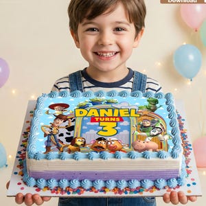 Op de afbeelding: Een rechthoekige taart met een witte en paarse basis, bedekt met een eetbare Toy Story-afbeelding met Woody, Buzz Lightyear en andere personages. De tekst luidt Daniel Turns 3. De taart is afgewerkt met blauwe glazuurranden.