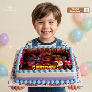 Puede incluir: Una tarta de cumpleaños decorada con personajes de un videojuego popular. La tarta tiene una base azul y morada, con las palabras "Happy 5th Birthday" y el nombre "Matthew". La tarta es sostenida por un niño sonriente.