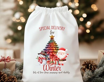 May include: White Christmas gift bag with a drawstring. The bag features a colourful Christmas tree, a snowman, and Santa Claus. Text on the bag reads "Special Delivery for Winter" and "lots of love from mummy and daddy."