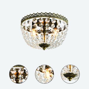 May include: A vintage-style ceiling light fixture with a bronze-colored metal frame and a multitude of clear crystal accents. The light has a rounded shape, with a decorative filigree border and a central cluster of crystals.