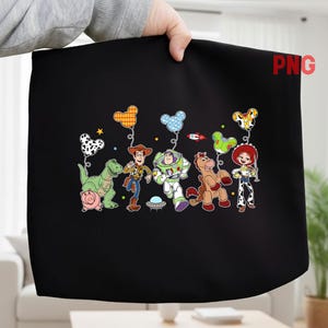 May include: Black fabric featuring a colorful graphic of Toy Story characters, including Woody, Buzz Lightyear, and Jessie. The design includes balloons shaped like Mickey Mouse heads. A pink pig, a green dinosaur, and a brown horse are also depicted.