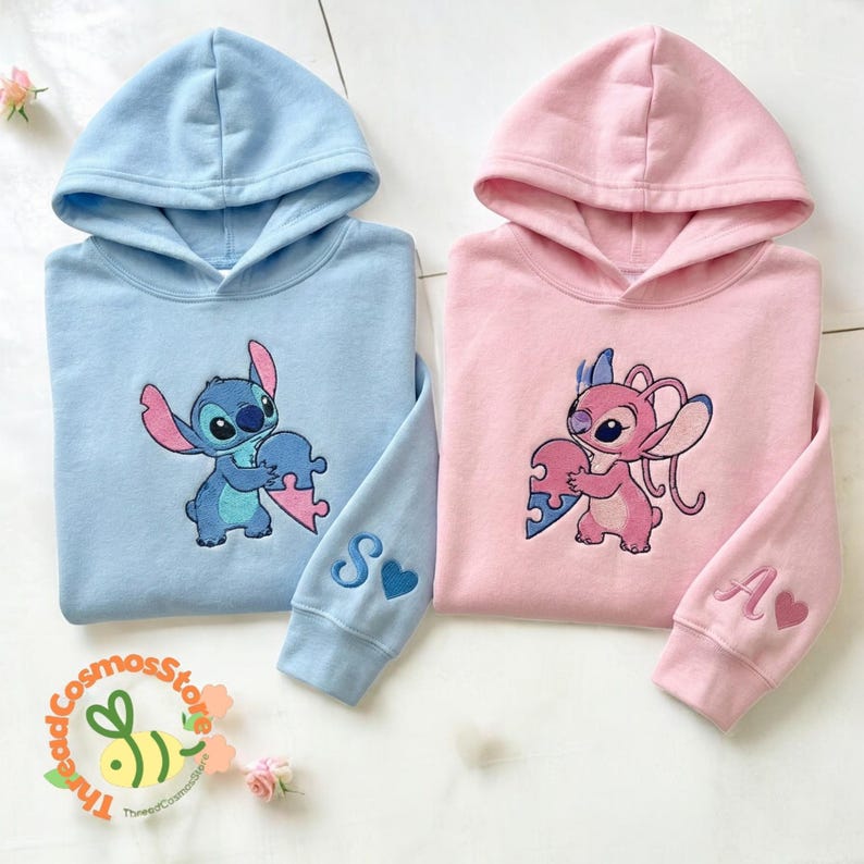 two hooded sweatshirts with cartoon characters on them, one in blue and one in pink.