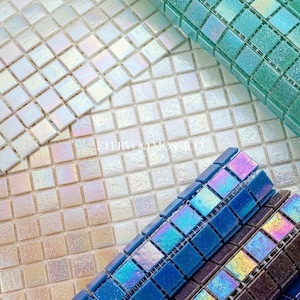 Puede incluir: Una colección de azulejos de mosaico cuadrados con un patrón de cuadrícula. Los azulejos muestran una variedad de acabados iridiscentes en blanco, verde azulado, azul y morado oscuro. El texto "FITRVOO MOSAIC" está impreso en blanco.