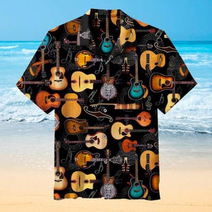 May include: Black short-sleeve button-down shirt featuring a repeating pattern of various guitars, mandolins, and musical notes in shades of brown, yellow, and blue. The shirt has a classic collar and is set against a beach backdrop.