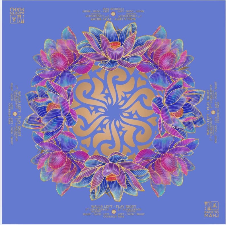 Pu&ograve; includere: Un grafico quadrato blu con un motivo mandala dorato al centro, circondato da un anello di fiori di loto stilizzati nei toni del viola, rosa e blu. Il testo sui bordi recita "WALLS LEFT + PLAY RIGHT" e "BACK TO MAHJ".
