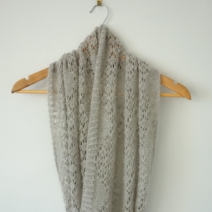 May include: A light gray crocheted infinity scarf with a delicate lace pattern.