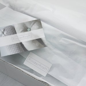 May include: A white box with a white tissue paper lining. The box has a white label with the text "KinderKraft" on it. The tissue paper is folded over the top of the box and has a white card with the text "KinderKraft" on it.