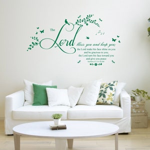 Könnte beinhalten: Ein weißes Sofa mit grünen Kissen in einem Wohnzimmer. Die Wand hinter dem Sofa hat einen grünen Vinyl-Aufkleber mit den Worten "The Lord bless you and keep you; the Lord make his face shine on you and be gracious to you; the Lord turn his face toward you and give you peace."