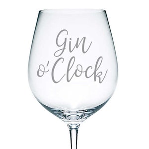 May include: A clear glass wine glass with the text "Gin o'Clock" etched on the side.