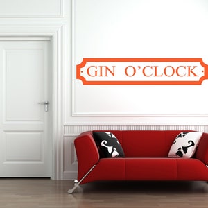 May include: A red couch with black and white pillows in a white room with a white door. A red sign with the text "GIN O'CLOCK" is on the wall.