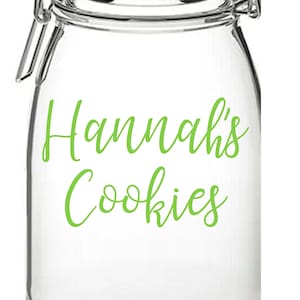 Op de afbeelding: Een glazen pot met een scharnierend deksel en een groen label met de tekst "Hannah's Cookies".