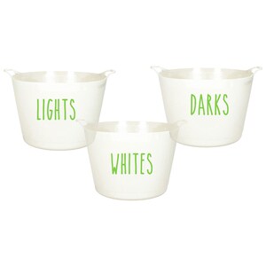 Op de afbeelding: Drie witte wasmanden met groene letters. De manden zijn gelabeld met "Lights", "Darks" en "Whites".