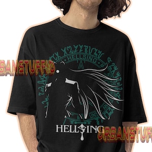 May include: Black t-shirt featuring a white and teal graphic design with the text "HELLSING" and other symbols. The design includes a silhouette of a character with flowing hair. The shirt is worn by a person.