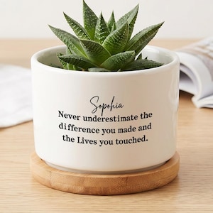 May include: A white ceramic cylindrical planter with a bamboo saucer base containing a green succulent plant. The front of the planter features the name Sophia in script and the text: Never underestimate the difference you made and the Lives you touched.