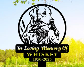 May include: Black metal garden stake featuring a Labrador Retriever holding a duck in its mouth, set within a circular frame. The text "In Loving Memory Of WHISKEY 1950-2025" is displayed below. The stake is designed for outdoor use.
