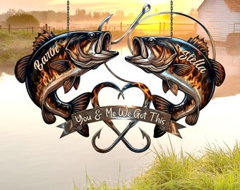 May include: Metal wall art featuring two fish facing each other with open mouths, each with a name. The design includes a heart, crossed hooks, and a banner with the text "You & Me We Got This". The art hangs from chains.