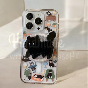 Può includere: Custodia trasparente per telefono con un motivo a gatto nero e adesivi a tema gatto. La custodia presenta un grande gatto nero al centro e piccole illustrazioni di gatti con mobili e piante. Il testo "Handmade with love Piling caseHK" è visibile.