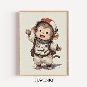 Peut inclure: Impression encadrée d'un singe de dessin animé en combinaison d'astronaute blanche et casque à rayure rouge. Le singe sourit et salue. Le logo de la NASA est visible sur la combinaison. L'impression est dans un cadre en bois.
