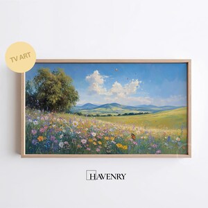 Puede incluir: Pintura de paisaje enmarcada que representa un prado vibrante lleno de coloridas flores silvestres bajo un cielo azul brillante con nubes. Un gran árbol se alza a la izquierda. El texto "TV ART" es visible. La firma "HAVENRY" está presente.