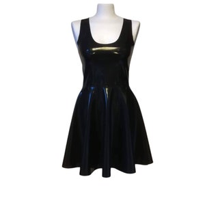 A black sleeveless skater dress made of shiny latex material.